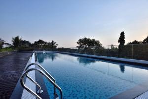 a swimming pool with a metal handrail next to it at Fairfield by Marriott Belagavi in Belgaum