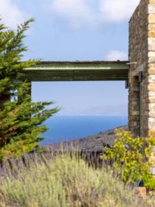 a view of the ocean through a brick building at Bella Resorts Andros in Andros