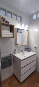 een badkamer met een wastafel, een spiegel en handdoeken bij Estudio Patio San Paulino II in Barbate