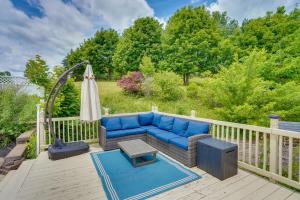 une terrasse avec un canapé bleu et un parasol dans l'établissement Expansive Upstate Home with Home Theater!, 