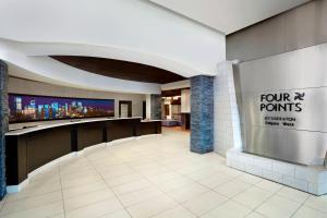 um lobby com um sinal de quatro pontos na parede em Four Points by Sheraton Hotel & Suites Calgary West em Calgary