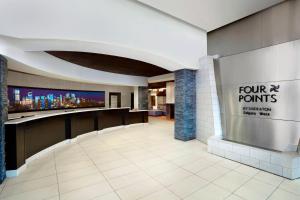 a lobby with a four points sign on the wall at Four Points by Sheraton Hotel & Suites Calgary West in Calgary