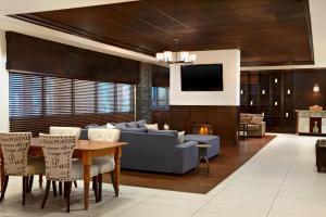 a living room with a blue couch and a table at Four Points by Sheraton Hotel & Suites Calgary West in Calgary