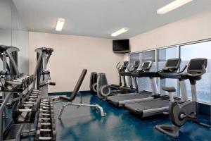a gym with treadmills and elliptical machines at Four Points by Sheraton Hotel & Suites Calgary West in Calgary