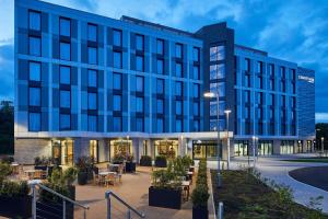 una vista esterna di un edificio con tavoli e sedie di Courtyard by Marriott Stoke on Trent Staffordshire a Newcastle under Lyme