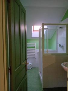 uma casa de banho com uma porta verde e um lavatório em Casa Los Lomas em Arenas de Iguña