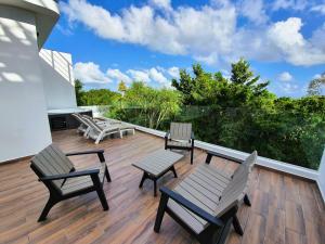 d'une terrasse avec des chaises et des tables. dans l'établissement Residence 8 min from the beach, à Puerto Morelos