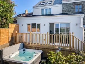 a hot tub on the back of a house at Rose Cottage in Abbotsham