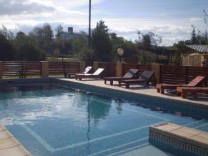 una piscina con 2 bancos en Hotel Foxes en Villa del Dique