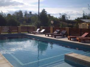 a swimming pool with two benches at Hotel Foxes in Villa del Dique