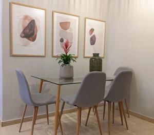 a dining room table with four chairs and a vase on it at Beautiful 1 bedroom flat near Olympic Stadium in Athens