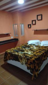 Cama en habitación con manta de leopardo en Pousada Alto das Galés, en Maragogi