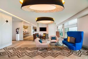 a lobby with blue chairs and a living room at Le Meridien Putrajaya in Putrajaya