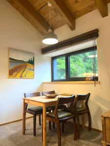 a dining room with a wooden table and chairs at apartmány V Lese in Bedřichov