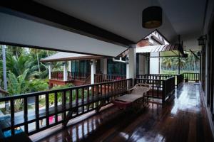 a balcony of a house with a bench on it at Coconut Tree Homestay in Ban Wa Thon