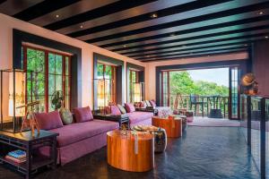 a living room with pink couches and a patio at Le Meridien Mahabaleshwar Resort & Spa in Mahabaleshwar