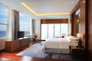 a bedroom with a large bed and a television in it at Four Points by Sheraton Manado in Manado
