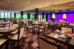a restaurant with tables and chairs and purple lighting at The Westin Leipzig in Leipzig