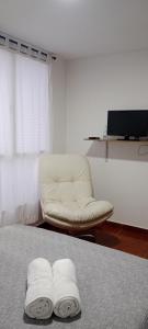 a room with a chair and two towels on a bed at Dulce hogar baño compartido in Chía