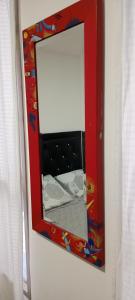 a mirror with a red frame on a wall at Dulce hogar baño compartido in Chía