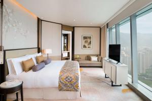 a bedroom with a large white bed and a television at Meixi Lake Hotel, a Luxury Collection Hotel, Changsha in Changsha