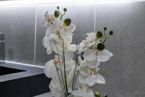 un vase rempli de fleurs blanches dans une cuisine dans l'établissement Foral Dreams, à Fajã de Cima 49 autres photos