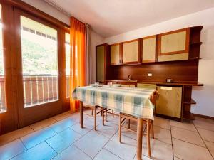 uma cozinha com uma mesa, um lavatório e uma janela em Elga Residence - Relax in Alta Valtellina - Bormio em Valdisotto