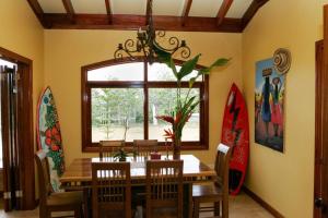 a dining room with a table and chairs and surfboards at Villa Pavones in Pavones