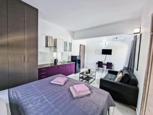 Habitación con cama, sofá y cocina. en Giorgis Luxury Apartments en Ayia Napa