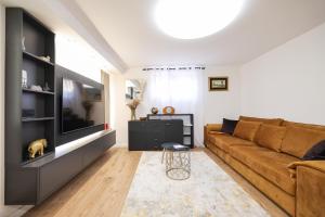 a living room with a couch and a flat screen tv at Oscar & Leo Apartments in Zadar