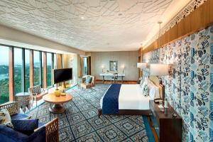 a hotel room with a bed and a living room at ITC Kohenur, a Luxury Collection Hotel, Hyderabad in Hyderabad
