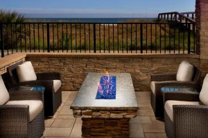 a patio with chairs and a table with a candle at Four Points by Sheraton Jacksonville Beachfront in Jacksonville Beach