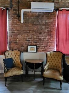 two chairs and a table in front of a brick wall at Olde Foundry Apt in Pictou