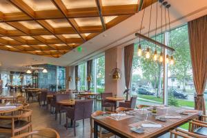 a restaurant with wooden ceilings and tables and chairs at Sheraton Novi Sad in Novi Sad