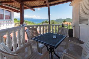 a patio with a table and chairs on a balcony at Apartments Ruža Dragove Dugi otok in Dragove