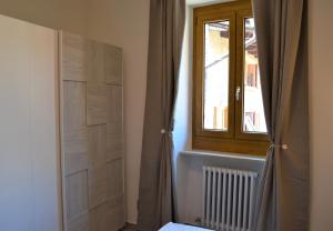 ein Schlafzimmer mit einem Fenster und einer Tür und einem Fenster in der Unterkunft Malcesine with Charme - Family&friends Superior 2 bedrooms apartment in Malcesine