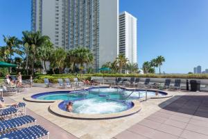 una piscina con sillas y un edificio en Florida Sunrise with Pool and Hot Tub en Miami