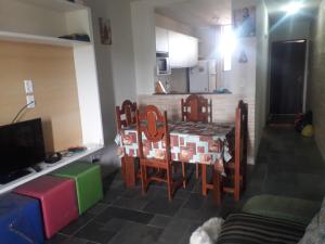 a kitchen with a table and chairs in a room at AP DA FABY in Barra de São Miguel