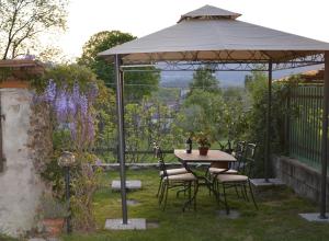a gazebo with a table and chairs under it at Casa Bartula in Bolzano Novarese