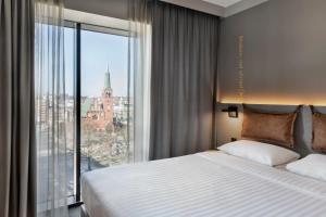 シュチェチンにあるMoxy Szczecin Cityのベッドルーム(大型ベッド1台、大きな窓付)