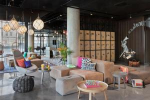 a lobby with couches and chairs and tables at Moxy Szczecin City in Szczecin