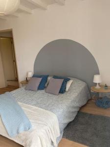 a bedroom with a large bed with blue pillows at Maison de village in Fanjeaux