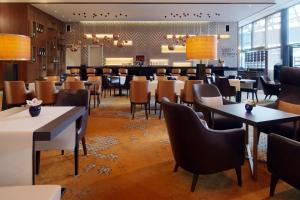 un restaurante con mesas y sillas y un bar en Sheraton Berlin Grand Hotel Esplanade, en Berlín