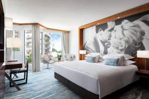 a hotel room with a bed with a large painting on the wall at JW Marriott Cannes in Cannes