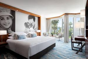 - une chambre avec un grand lit et un bureau dans l'établissement JW Marriott Cannes, à Cannes