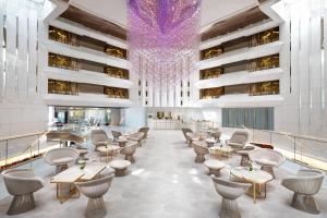 a lobby with tables and chairs and a chandelier at JW Marriott Cannes in Cannes