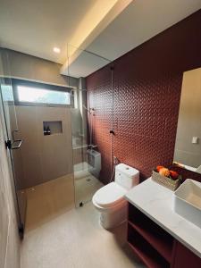 a bathroom with a toilet and a glass shower at Casa Talia Beach House in Lobo