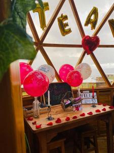una mesa con globos rojos y blancos y corazones en ella en Lago De Tota Glamping, en Tota