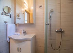 La salle de bains est pourvue d'un lavabo et d'une douche. dans l'établissement Sunny Apartments, à Stomorska