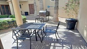 een picknicktafel en stoelen met een grill en een vuilnisbak bij Villa Sonari 4, Inside a private complex of 4 By Kivoya in Puerto Peñasco